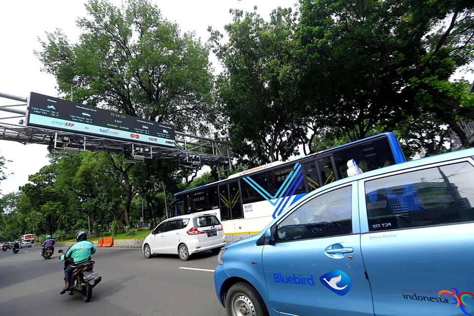 Pengendara melintas di antara alat teknologi sistem jalan berbayar elektronik di Jalan Merdeka Barat, Jakarta, Jumat (14/2/2020)