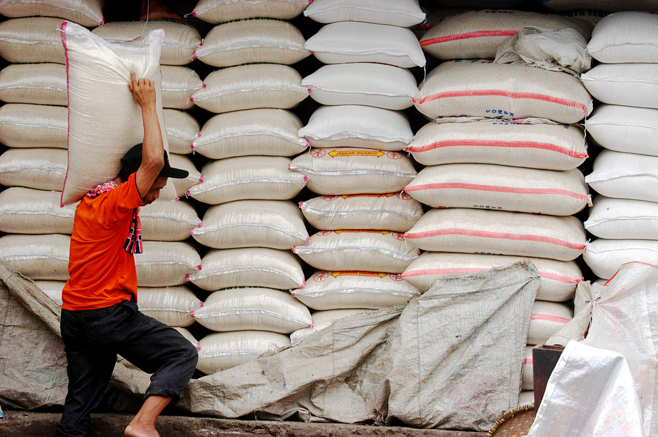 Pekerja mengangkat beras untuk siap dipasarkan di Jakarta.