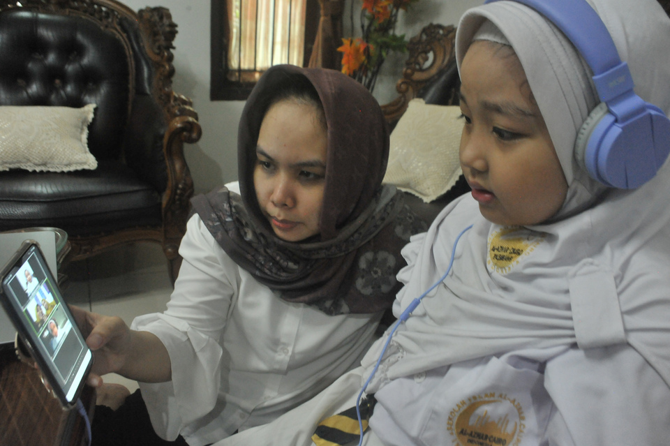 Siswa Sekolah Dasar didampingi orang tua melakukan Pembelajaran Jarak Jauh (PJJ) dengan sistem daring pada hari pertama tahun ajaran baru 2020-2021 di Palembang, Sumatera Selatan, Senin, 13 Juli 2020. 