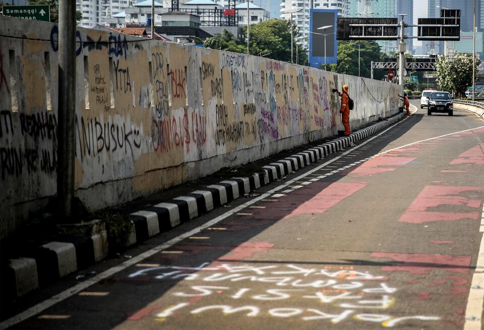 Petugas PPSU tengah membersihkan coretan pascademo di kawasan DPR/MPR, Jakarta, Jumat, 17 Juli 2020.