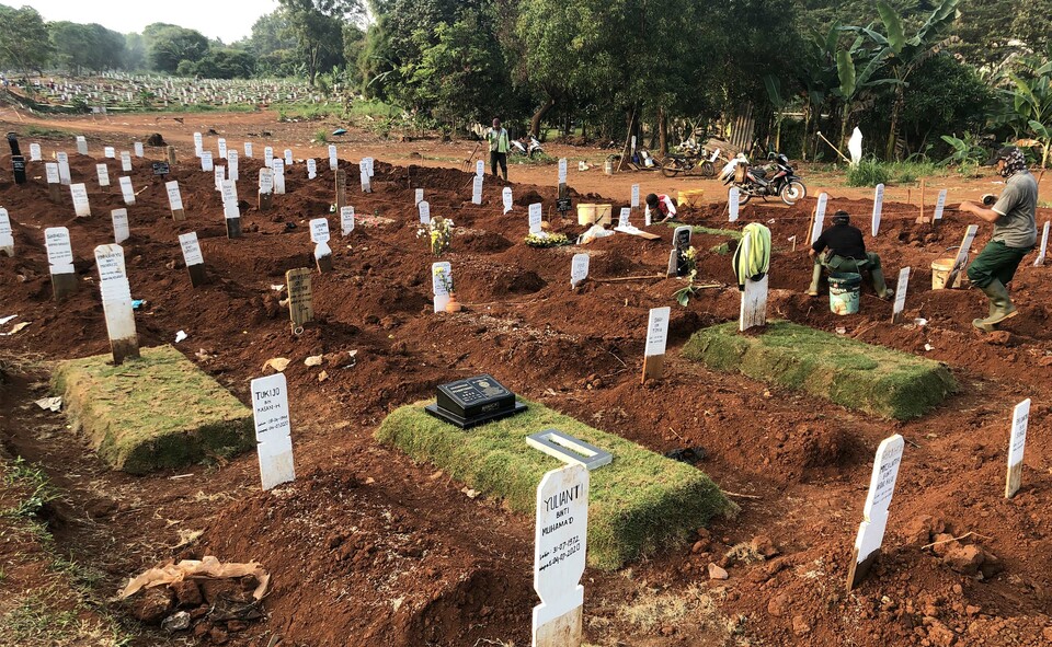 Petugas pemakaman melakukan perawatan terhadap makam pasien COVID-19 yang baru dimakamkan berapa hari terakhir di TPU Pondok Rangon, Jakarta Timur, Jumat, 17 Juli 2020. 