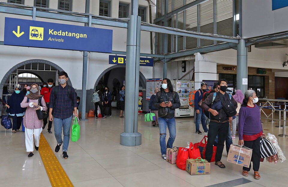 Penumpang kereta api Dharmawangsa dari Surabaya tiba di Stasiun Pasar Senen, Jakarta, Minggu, 3 Januari 2021.