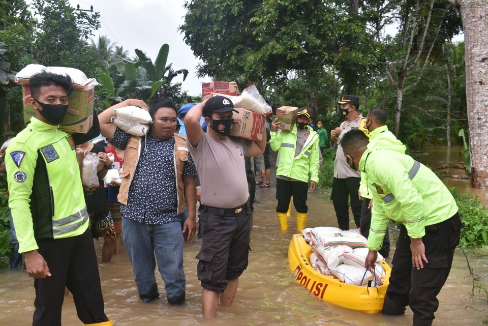 Polisi membagikan sambako dan makanan kepada warga terdampak banjir, di Kalimantan Selatan.