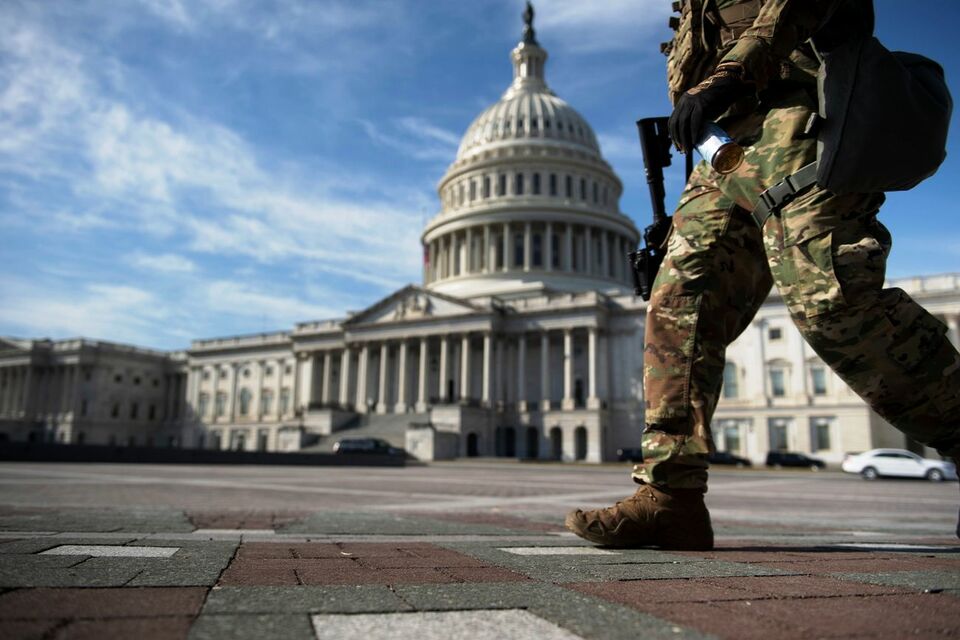Seorang anggota Garda Nasional berjalan di halaman gedung Capitol Hill, Washington DC, tempat dimulainya sidang hari pertama pemakzulan mantan presiden Donald Trump oleh Senat, 9 Februari 2021.