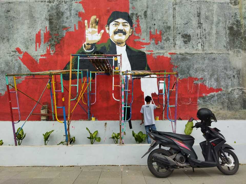 Seniman saat melakukan aksi muralnya sebagai hadiah untuk Wali Kota Solo FX Hadi Rudyatmo, yang sebentar lagi memasuki purnatugas.