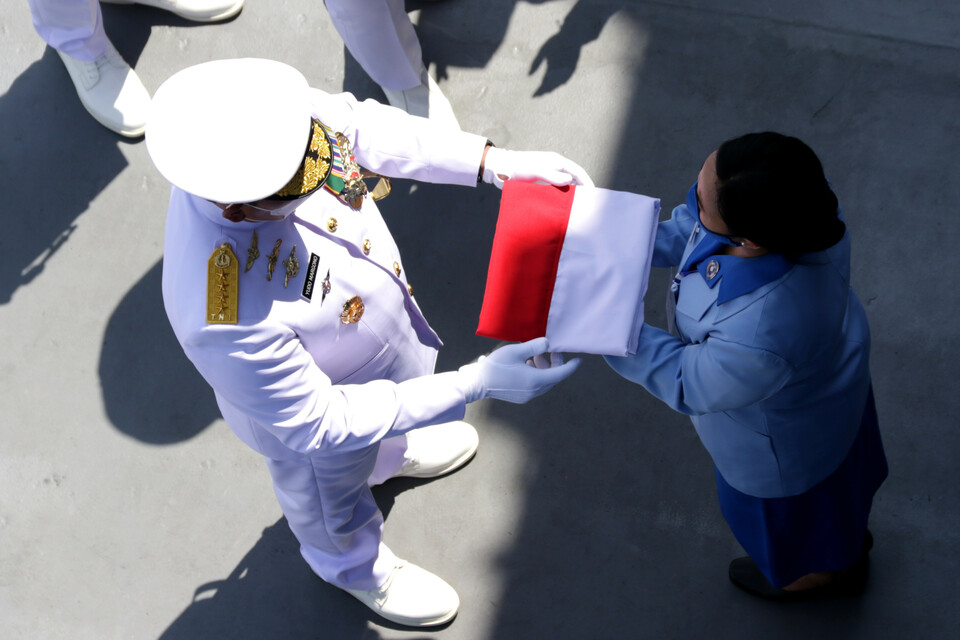 Kasal Laksamana Yudo Margono menyerahkan bendera merah putih kepada keluarga awak KRI Nanggala-402 di geladak KRI Dr Soeharso-990, di perairan utara Bali, Bali, Jumat 30 April 2021). 