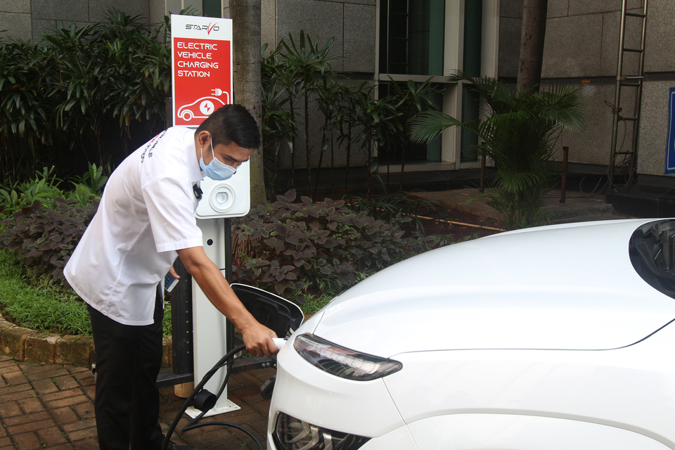 Pengendara mobil listrik mengaktifkan SPKLU dengan aplikasi di smartphone untuk mengisi baterai kendaraannya, Jakarta, Rabu (2/6/2021). Berdasarkan riset Eaton, Indonesia memimpin dalam hal prioritas perluasan target bauran energi baru terbarukan di Asia Pasifik. Sebanyak 83 % perusahaan di Indonesia memandang peningkatan penggunaan EBTsebagai prioritas bisnis utama.