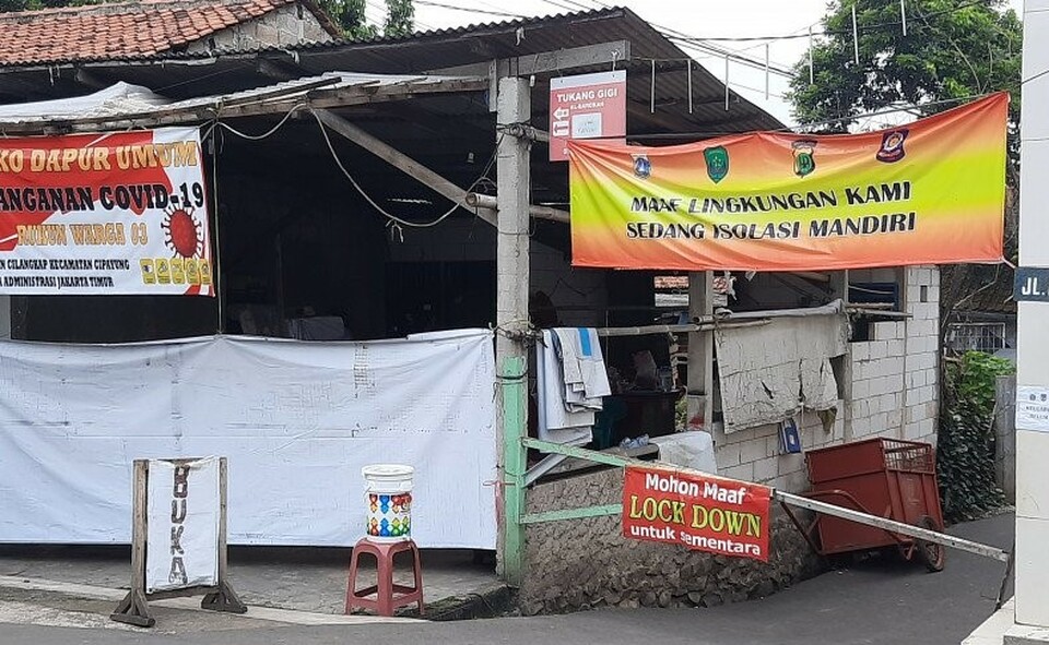 Spanduk berisi pengumuman lockdown terpasang di akses masuk RT 03 RW 03 Cilangkap, Jakarta, Rabu 2 Juni 2021. 