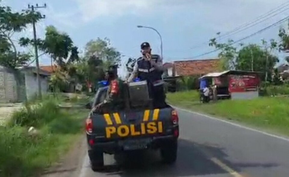Petugas gabungan TNI dan Polri di Bangkalan, Jawa Timur, berkeliling dengan pengeras suara melarang warga keluar rumah dan bepergian ke Surabaya, guna mencegah penyebaran Covid-19, Senin, 7 Juni 2021. 
