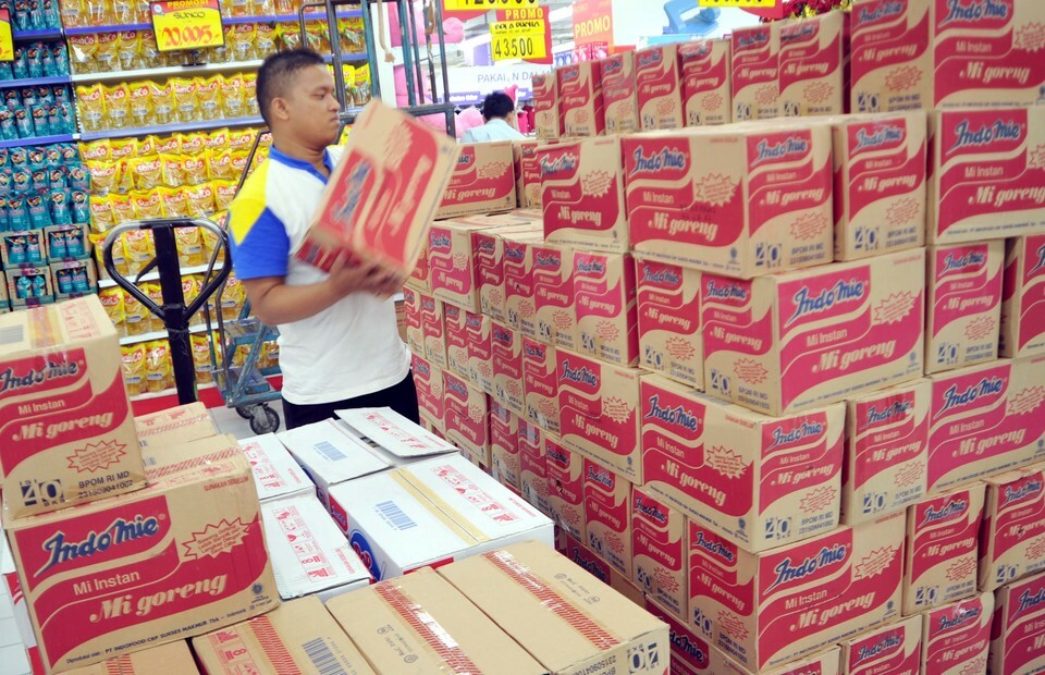 Karyawan merapikan dus berisi mi merek Indomie produksi Indofood.