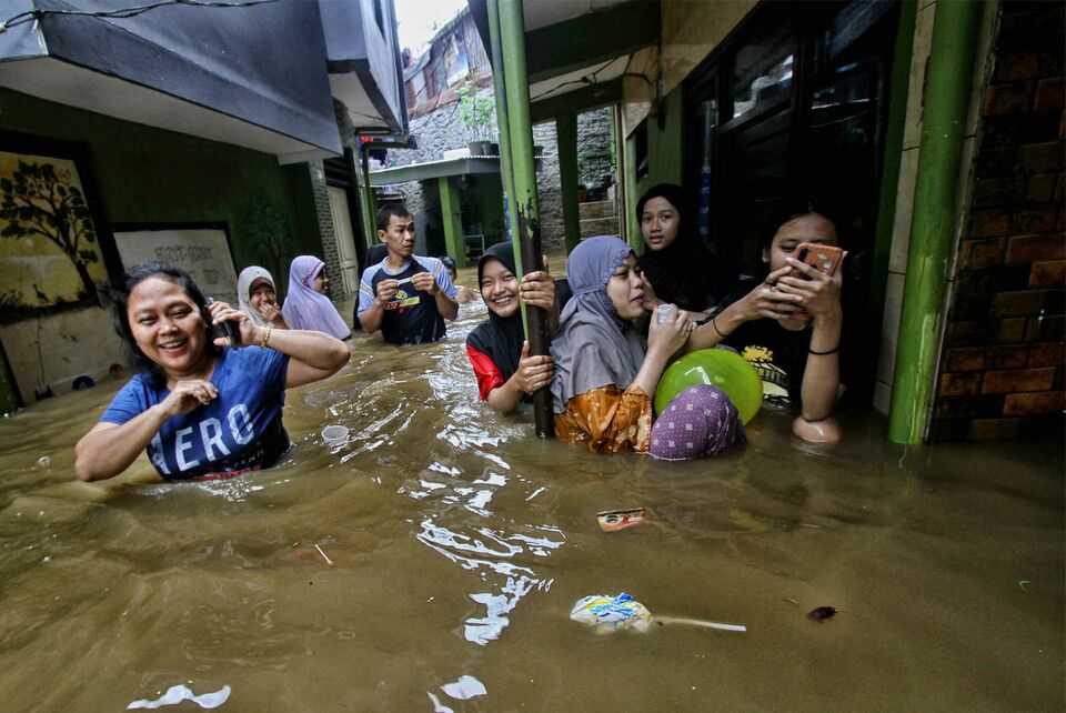 Warga beraktivitas di tengah banjir kiriman yang melanda Wilayah RW 04 dan RW 05 Kampung Melayu, Jakarta Timur, atau biasa yang disebut daerah Kebon Pala, Senin 8 November 2021.