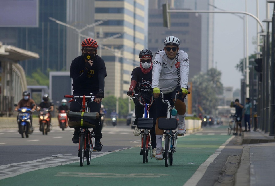 Warga bersepeda di kawasan Jalan Thamrin-Sudirman saat pemberlakuan PPKM level 1 di Jakarta, Minggu, 21 November 2021.
