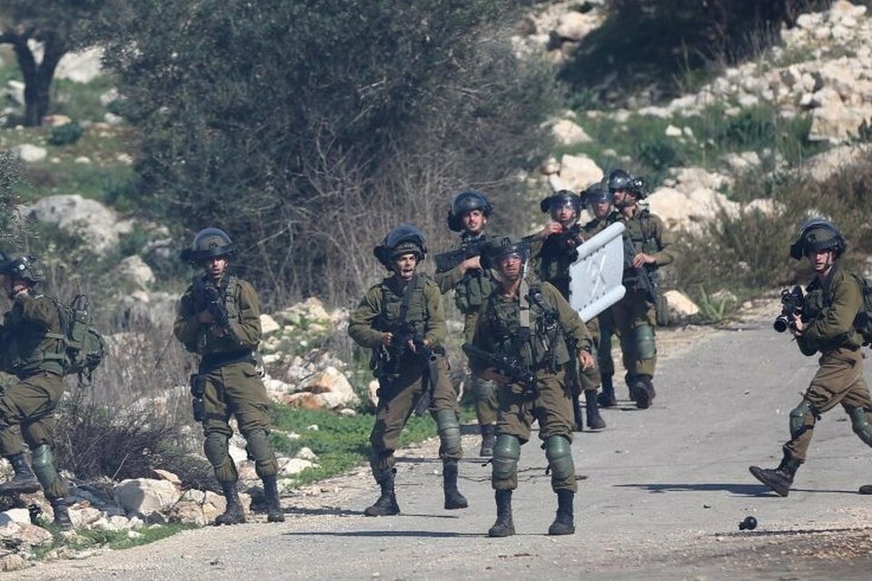 Tentara Israel bersiaga dengan senjata saat bentrokan dengan para pengunjuk rasa Palestina di Tepi Barat.
