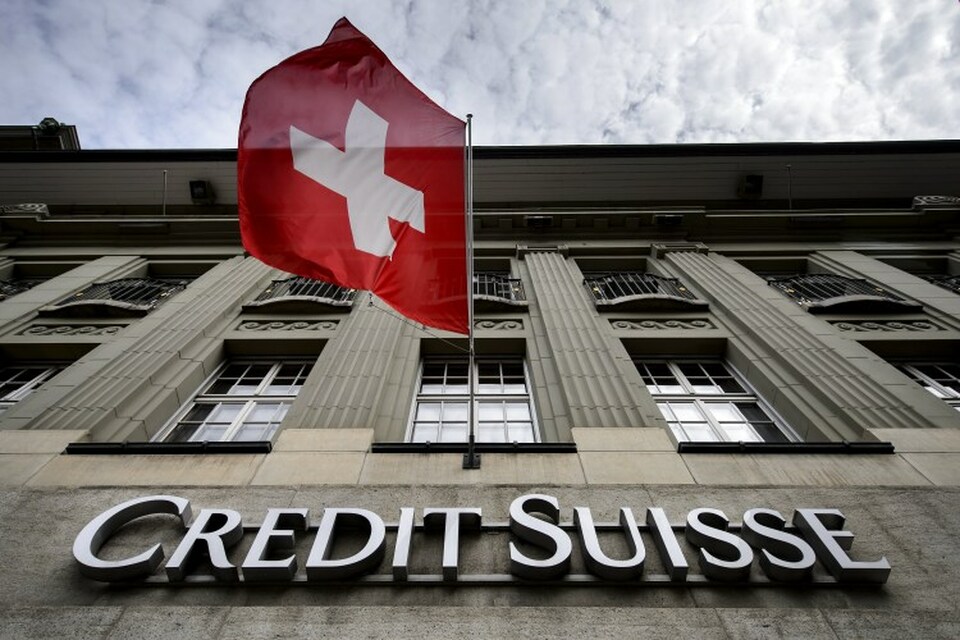 Bendera Swiss berkibar di atas tanda bank Swiss Credit Suisse pada 8 Mei 2014 di Bern, Swiss