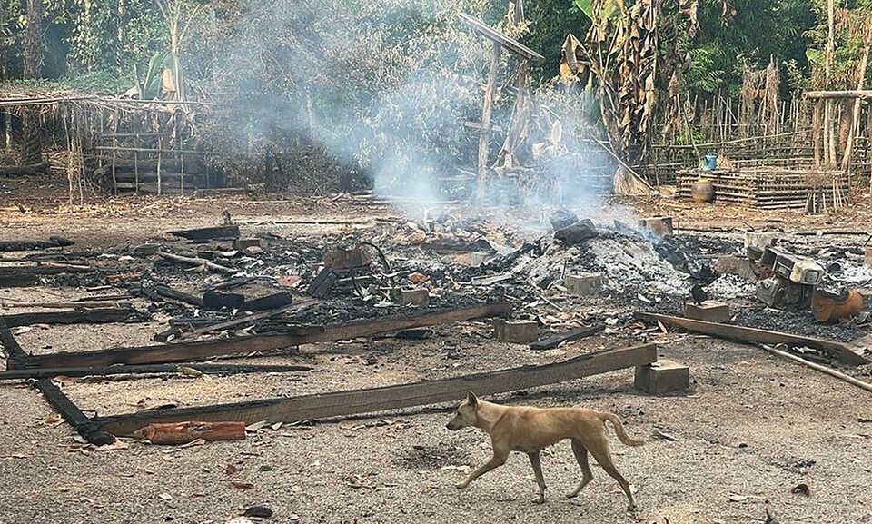 Seekor anjing berlari melewati sisa-sisa bangunan yang terbakar setelah serangan udara dan serangan mortir oleh militer Myanmar, di sebuah desa di distrik Doo Tha Htoo di negara bagian Kayin timur Myanmar.