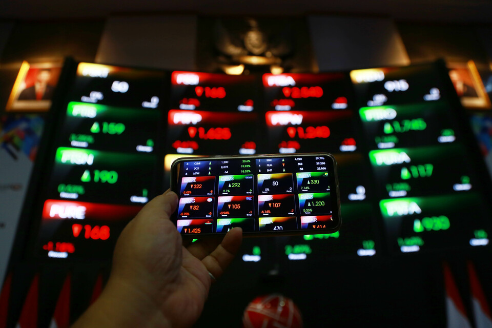 Pengunjung mendokumentasikan pergerakan harga saham di Bursa Efek Indonesia (BEI), di Jakarta.
