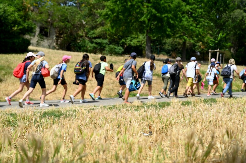 Anak-anak berjalan di taman umum di Marseille, Prancis selatan, pada 16 Juni 2022, di mana rumput mengering selama beberapa minggu tanpa hujan saat Prancis menghadapi gelombang panas.