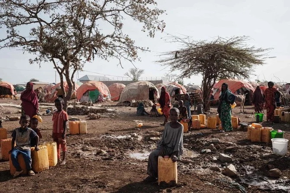 Orang-orang menunggu air dengan kontainer di satu kamp, ??salah satu dari 500 kamp pengungsi internal (IDP) di kota, di Baidoa, Somalia pada 13 Februari 2022.