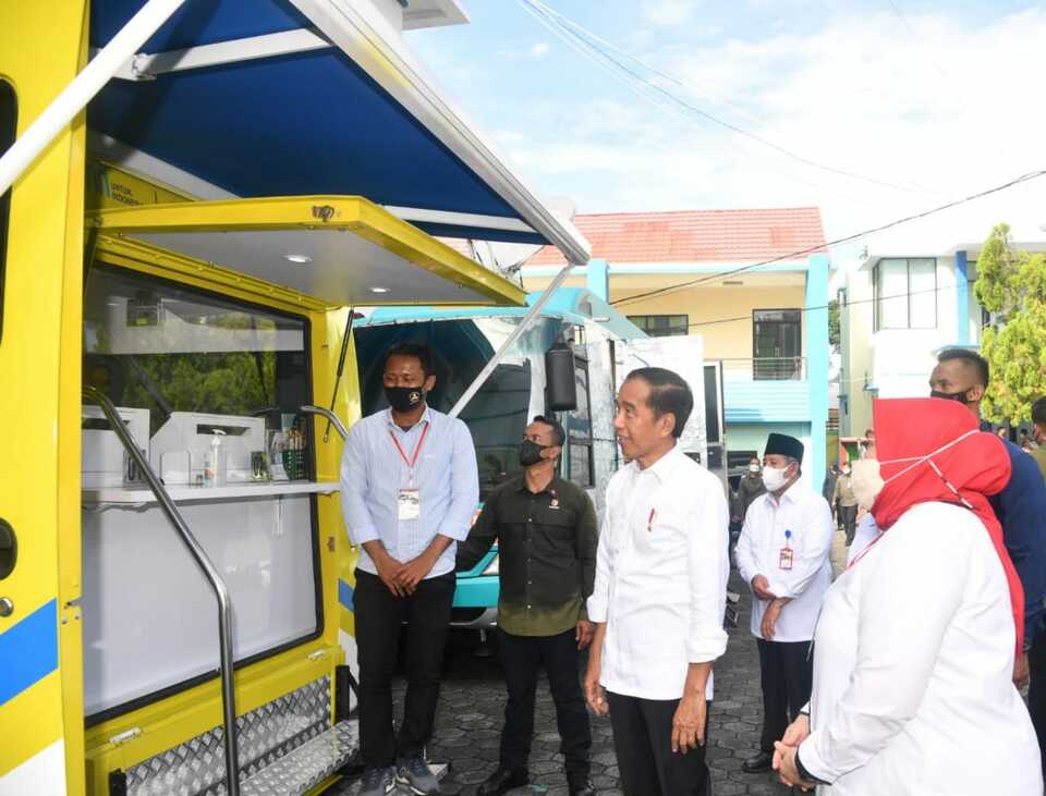 Presiden Jokowi didampingi Menteri Ketenagakerjaan Ida Fauziyah menyaksikan peserta penerima Bantuan Subsidi Upah (BSU) melakukan penarikan dana melalui ATM pada Mobil Kas Keliling (MKK) Bank BTN di Ternate, Maluku Utara, Selasa 28 September 2022.