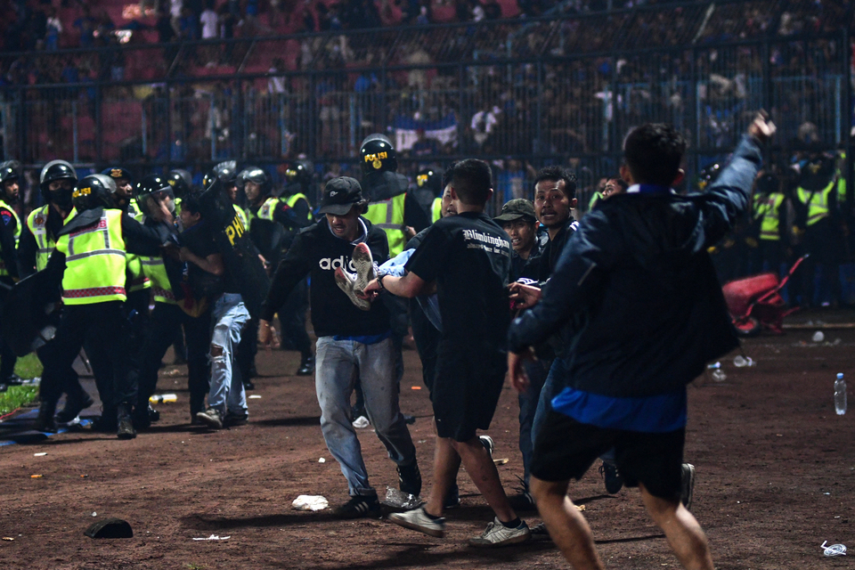 Seorang penonton korban kerusuhan dibawa untuk dievakuasi dalam pertandingan sepak bola antara Arema FC dan Persebaya Surabaya di stadion Kanjuruhan di Malang, Jawa Timur, Sabtu, 1 Oktober 2022.