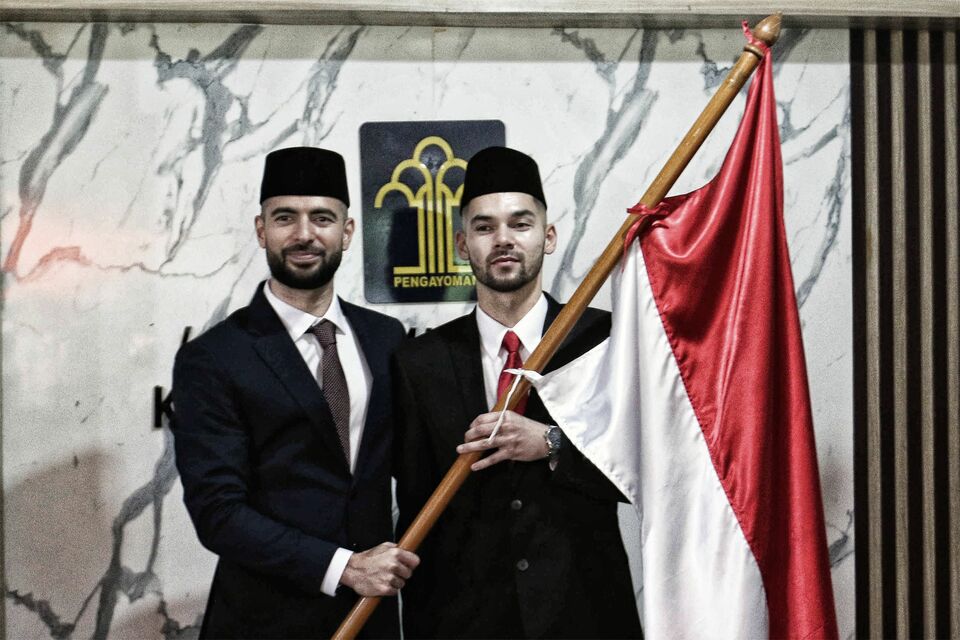 Pesepak bola Sandy Walsh (kanan) dan Jordi Amat (kiri) memegang Bendera Merah Putih usai membacakan Sumpah Janji Setia Pewarganegaraan di Kantor Wilayah Kemenkum HAM DKI Jakarta, Kamis, 17 November 2022.