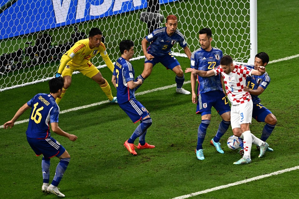 Penyerang Kroasia Andrej Kramaric (tengah) berusaha menjebol gawang Jepang.