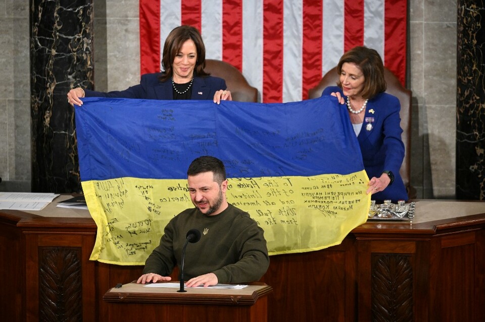 Presiden Ukraina Volodymyr Zelensky berpidato di hadapan Kongres AS saat Wakil Presiden AS Kamala Harris (kiri) dan Ketua DPR AS Nancy Pelosi memegang bendera nasional Ukraina di Washington, DC pada 21 Desember 2022.