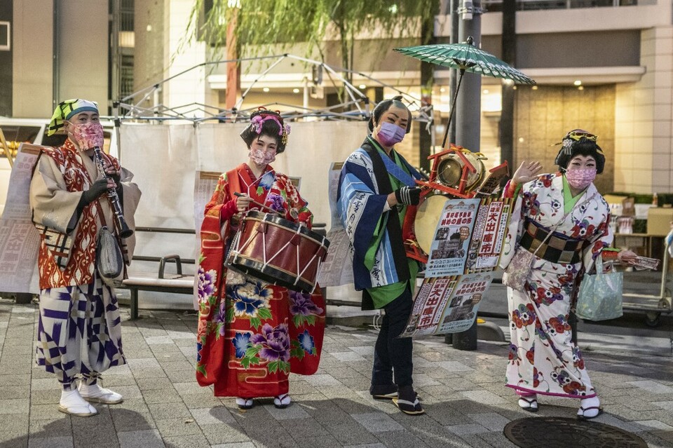 Warga Jepang mengenakan kimono di jalan saat mereka mengiklankan pekan raya akhir tahun di distrik Nihonbashi Tokyo pada 26 Desember 2022.