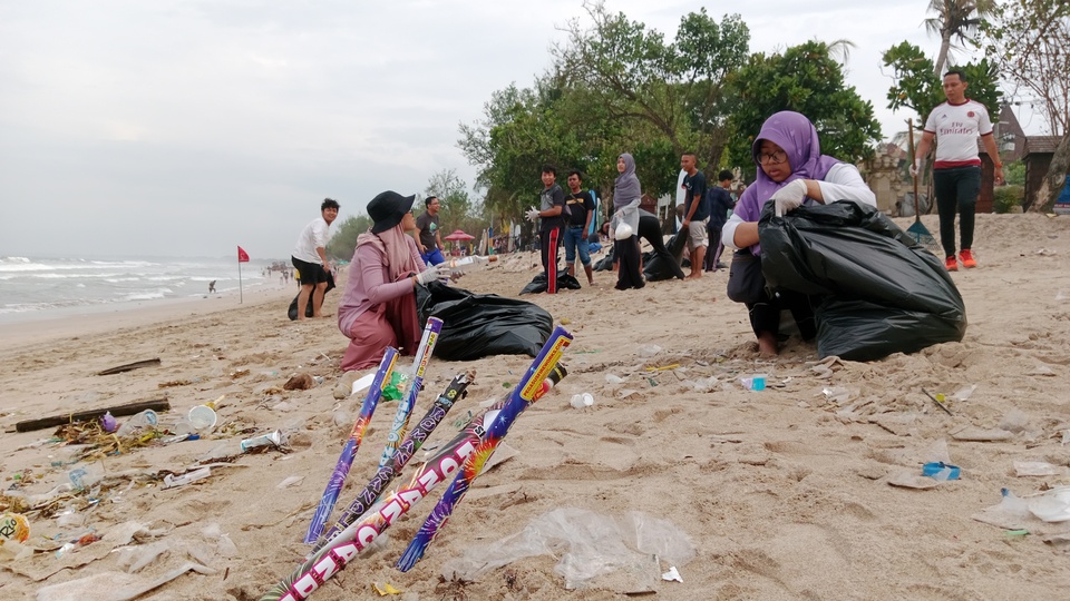 Komunitas bersih sampah pantai sedang membersih sampah di Pantai Kuta, Kabupaten Badung usai perayaan malam Tahun Baru 2023, Minggu (1/1/2023). Sampah yang menumpuk di Pantai Kuta tidak hanya karena pengunjung saat malam tahun baru tetapi juga akibat cuaca.