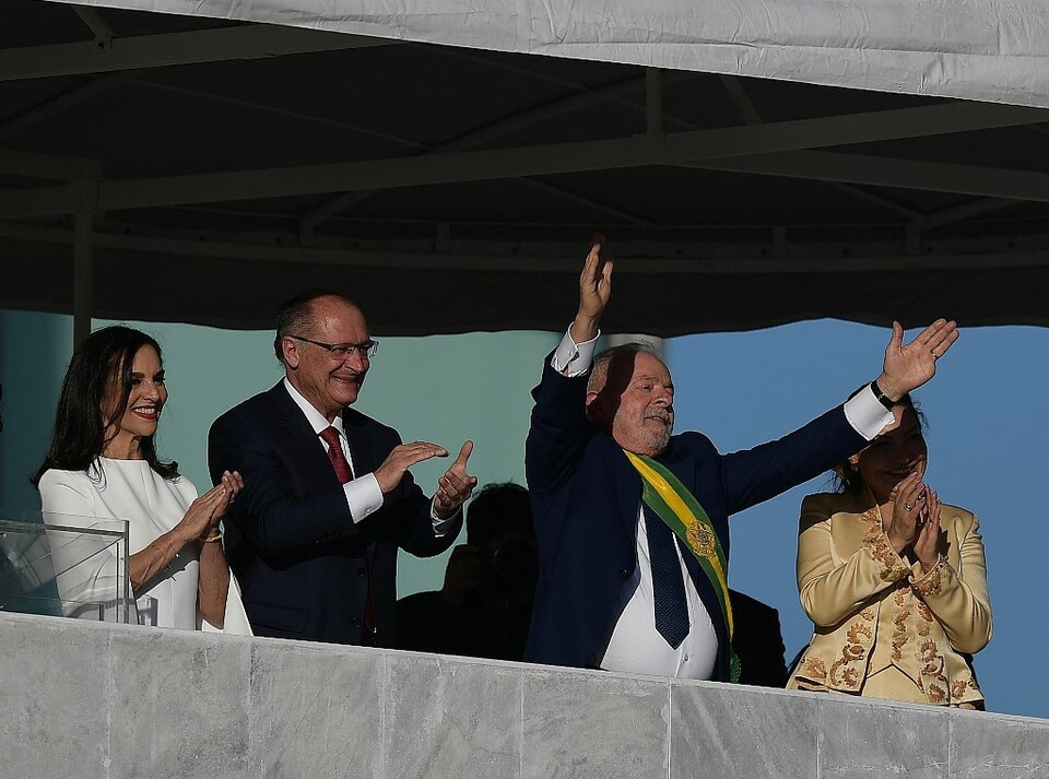 Presiden baru Brasil Luiz Inacio Lula da Silva (tengah) mengangkat tangannya saat berdiri di samping Wakil Presiden baru Geraldo Alckmin dan istri mereka, Ibu Negara Rosangela da Silva dan Maria Lucia Ribeiro Alckmin, selama upacara pelantikannya di Istana Planalto di Brasilia pada 1 Januari 2023.