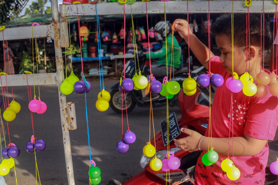 Seorang anak mencoba permainan lato-lato yang dijual di Cibinong, Kabupaten Bogor, Jawa Barat, Jumat  6 Januari 2023. 