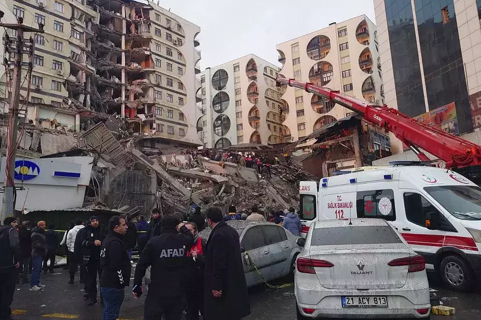 Petugas penyelamat dan tim medis berusaha menjangkau warga yang terjebak di bangunan yang runtuh setelah gempa bumi di Diyarbakir, Turki, Senin, 6 Februari 2023.