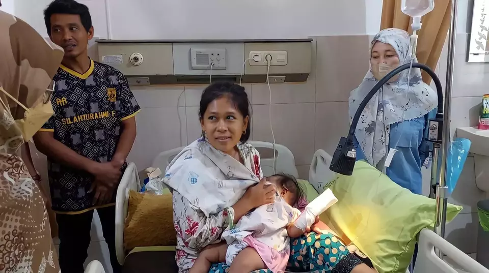 DN (baju biru), perawat yang menyebabkan jari bayi tergunting menjenguk korban.
