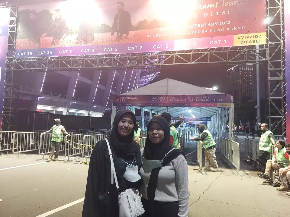 Winda dan Ira penggemar grup musik Westlife yang rela bereuforia dari luar panggung di Stadion Glora Bung Karno, Jakarta, Sabtu (11/2/2023) malam.