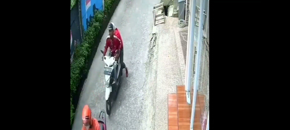 Tangkapan layar rekaman CCTV menunjukkan pelaku tabrak lari di Depok sedang membawa korbannya. Pelaku kemudian membuang korbannya di sebuah kebun kosong. 