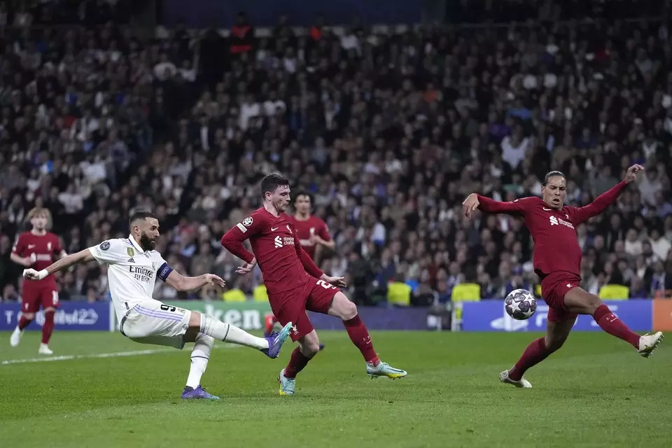 Penyerang Real Madrid, Karim Benzema (kiri) melepaskan tendangan saat melawan Liverpool.