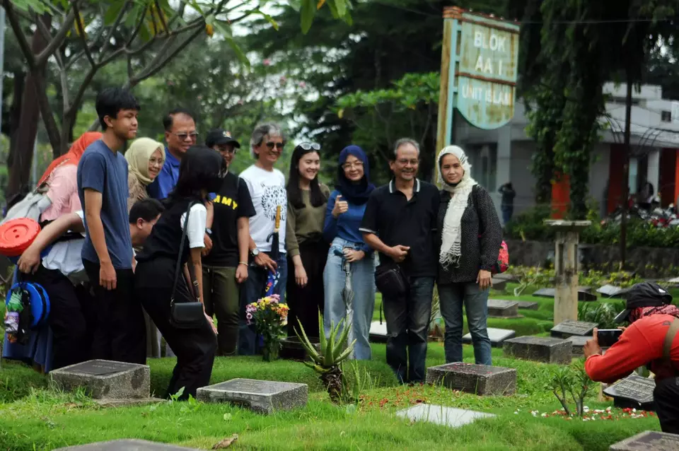 Peziarah berfoto usai ziarah kubur di TPU Karet Bivak, di Jakarta, Minggu, 19 Maret 2023.