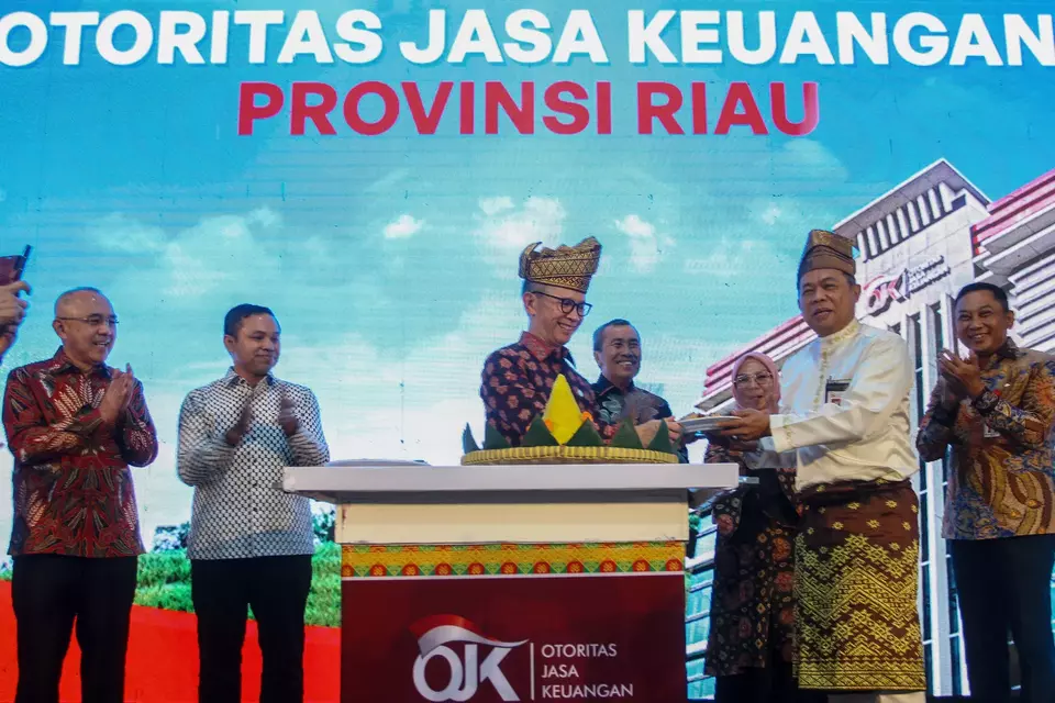 Ketua Dewan Komisioner Otoritas Jasa Keuangan (OJK) Mahendra Siregar (tengah) bersama Gubernur Riau Syamsuar (keempat kanan) menyerahkan potongan nasi tumpeng kepada Kepala Kantor OJK Riau Muhamad Lutfi (kedua kanan) saat meresmikan penggunaan gedung Kantor OJK Provinsi Riau, di Pekanbaru, Riau, Jumat (17/3/2023).