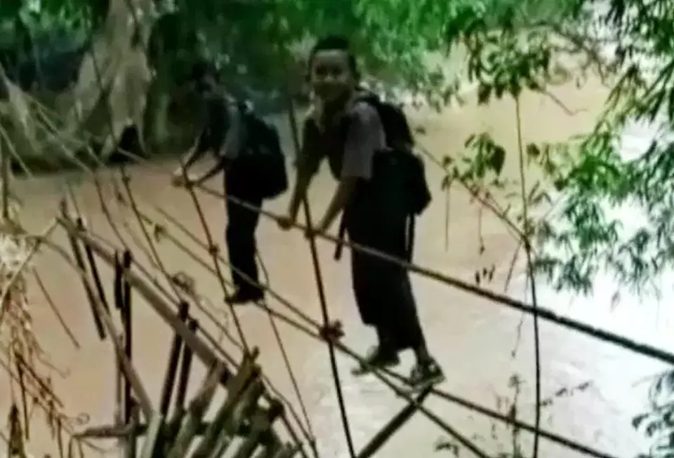 Siswa Sekolah Dasar (SD) Kampung Tiyuh Balak 2, Kecamatan Gunung Labuhan, Kabupaten Way Kanan, Lampung harus bertaruh nyawa menyeberangi sungai Way Besai untuk dapat ke sekolah. Siswa harus bergelantungan pada tali pada jembatan gantung untuk sampai ke sekolah, Jumat, 24 Maret 2023.