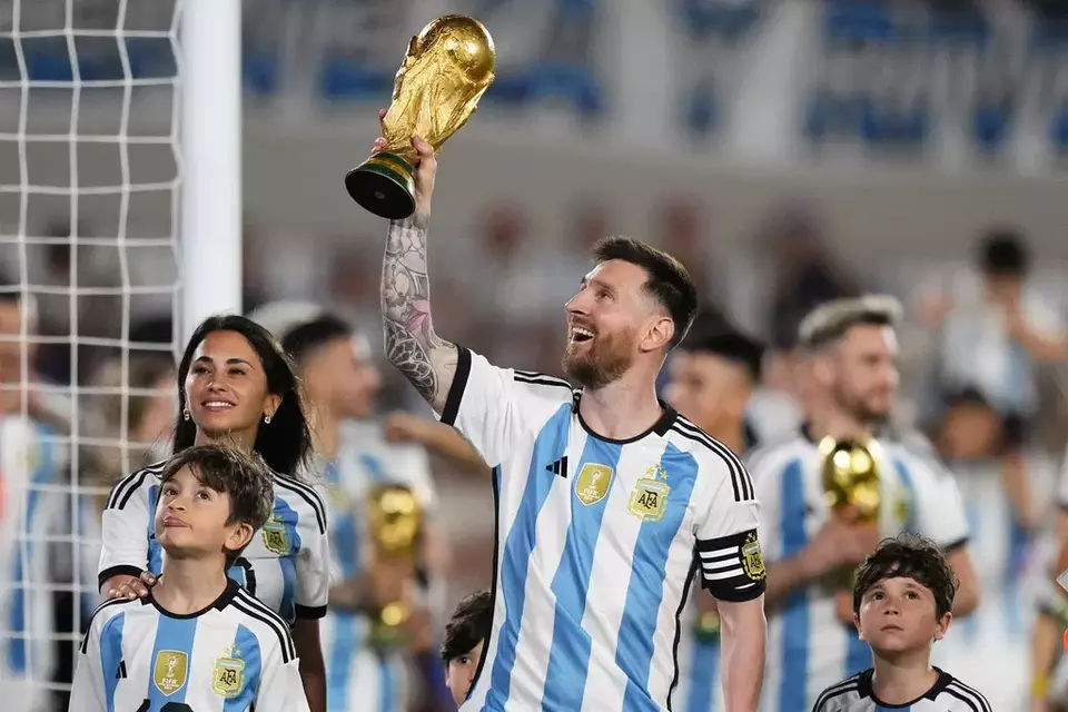 Lionel Messi memamerkan trofi Piala Dunia 2022 usai mengalahkan Panama di Stadion El Monumental.