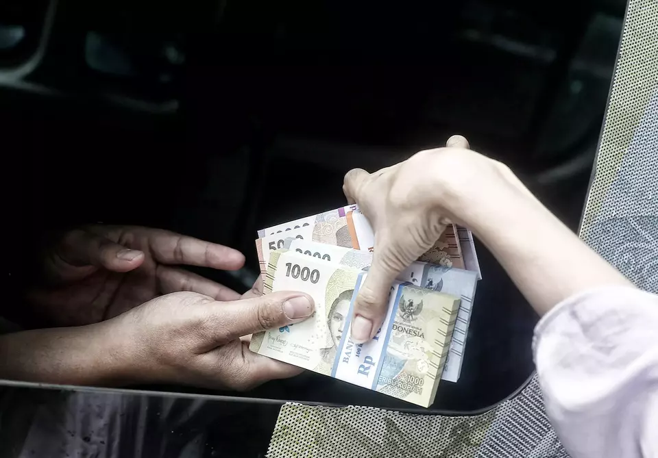Warga menukarkan pecahan uang baru pada layanan mobil kas keliling Bank Indonesia di Pasar Kopro, Tanjung Duren, Jakarta Barat, Rabu (29/3/2023).