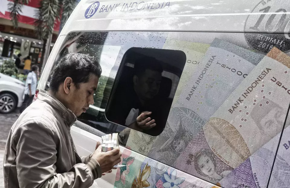 Warga menukarkan pecahan uang baru pada layanan mobil kas keliling Bank Indonesia di Pasar Kopro, Tanjung Duren, Jakarta Barat, Rabu (29/3/2023).