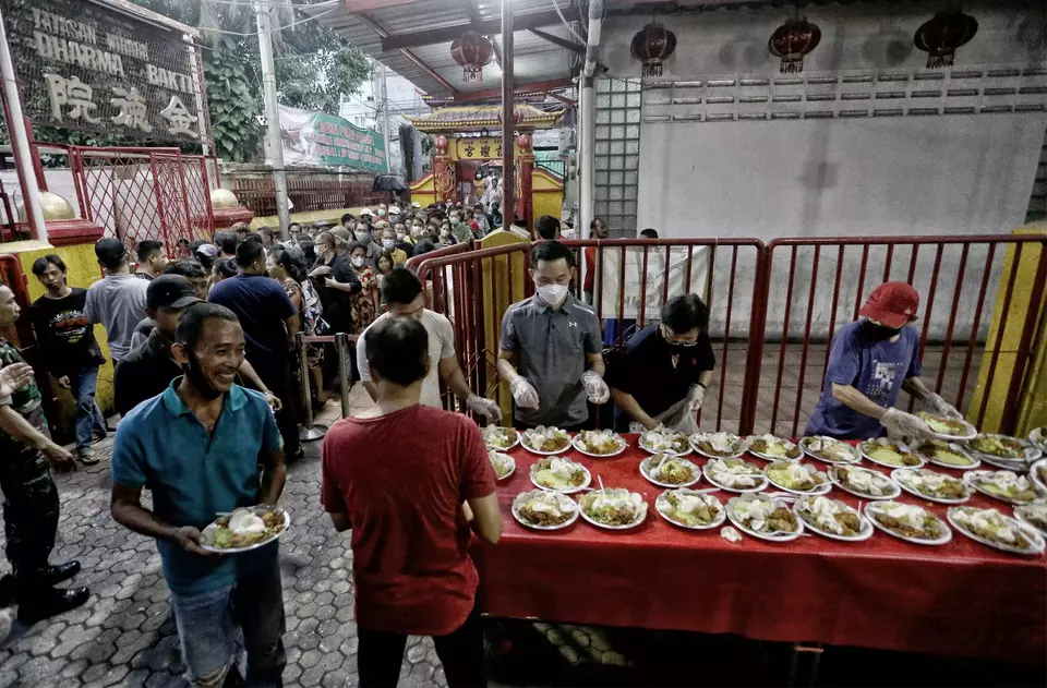 Warga sekitar antri untuk menyantap hidangan berbuka puasa yang disedikan Vihara Dharma Bhakti, Jakarta Barat, Jumat (31/3/2023).