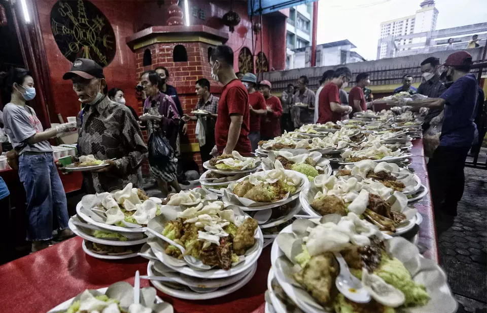 Warga sekitar antri untuk menyantap hidangan berbuka puasa yang disedikan Vihara Dharma Bhakti, Jakarta Barat, Jumat (31/3/2023).