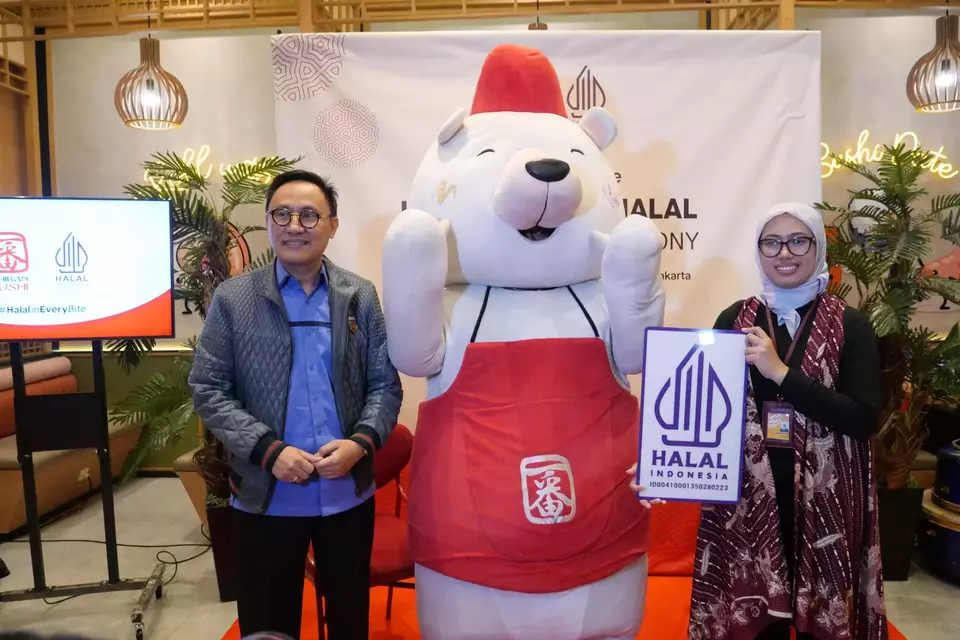 Kepala Badan Penyelenggara Jaminan Poduk Halal Muhammad Aqil Irham (kiri) menyerahkan sertifikat halal kepada VP Operation Eatwell Culinary Indonesia Mustarofah Ahmad (kanan), di restoran Ichiban Sushi Kuningan City Mall, Jakarta Selatan, Jumat (31/3/2023).