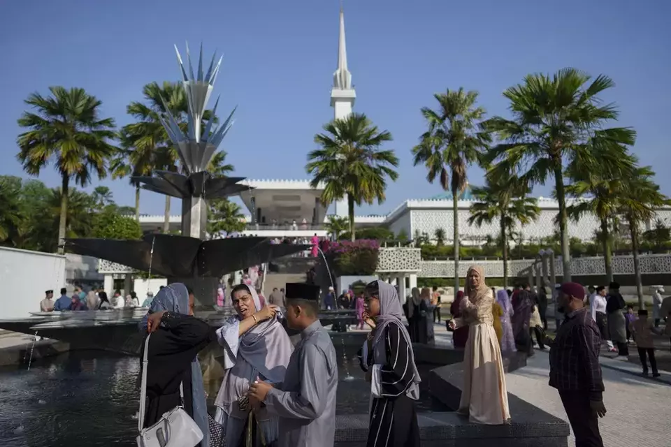 Umat Muslim di Malaysia keluar dari Masjid Nasional usai melaksanakan salat Idulfitri, di Kuala Lumpur, Sabtu, 22 April 2023.