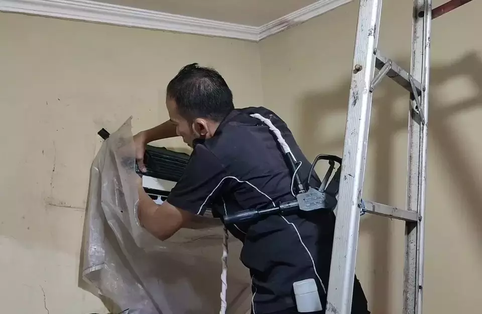 Tukang servis membersihkan AC di Depok, Jawa Barat, Rabu 17 Mei 2023.
