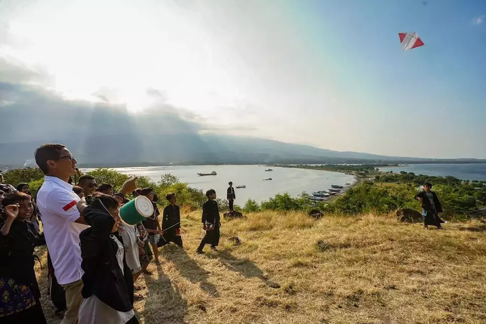 Menparekraf Sandiaga Uno bermain layang-layang bersama masyarakat sambil menikmati keindahan Bukit Kayangan di Desa Wisata Labuhan Lombok yang masuk ke dalam 75 besar Anugerah Desa Wisata Indonesia (ADWI) 2023, Lombok Timur, Rabu (17/5/2023).