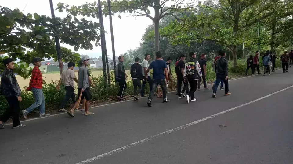 Sejumlah warga terlihat membawa kayu dan besi di Jalan Mochamad Yamin, Kabupaten Kuningan, Jawa Barat, Rabu 24 Mei 2023.