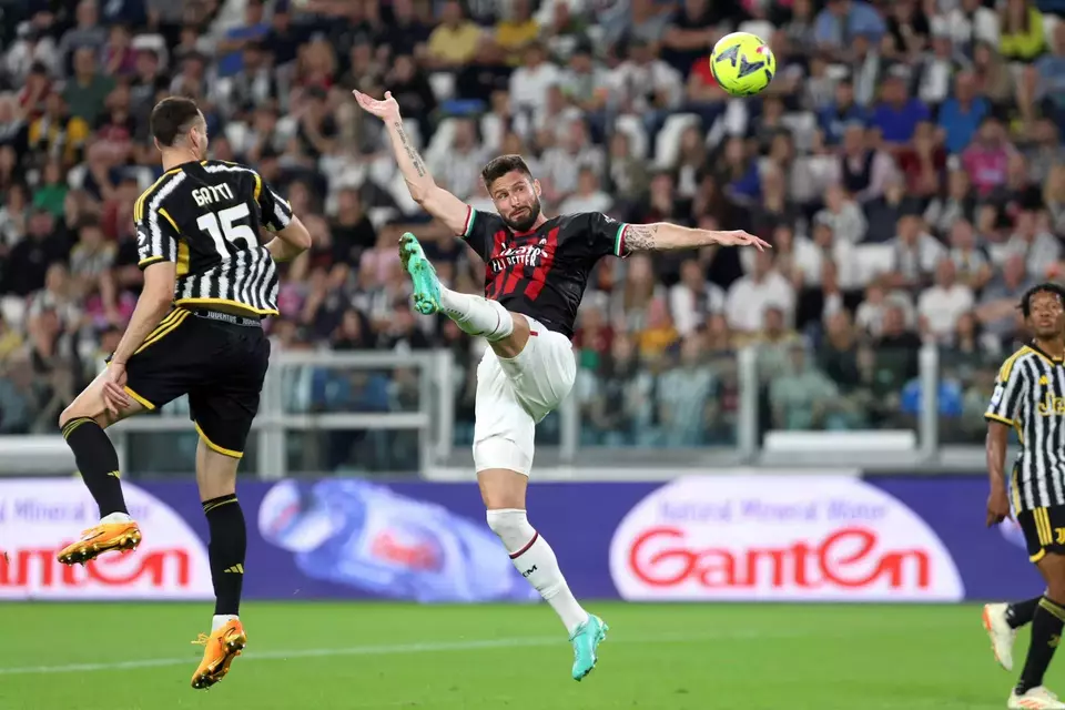 Pemain AC Milan Olivier Giroud berebut bola dengan bek Juventus Federico Gatti (kiri) pada pertandingan Liga Italia di Stadion Allianz, Turin, Minggu 28 Mei 2023. 